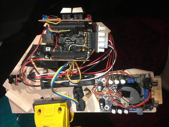 Controller wing from behind: Bela board, amplifier and IMU sensor wired together like colored spaghetti